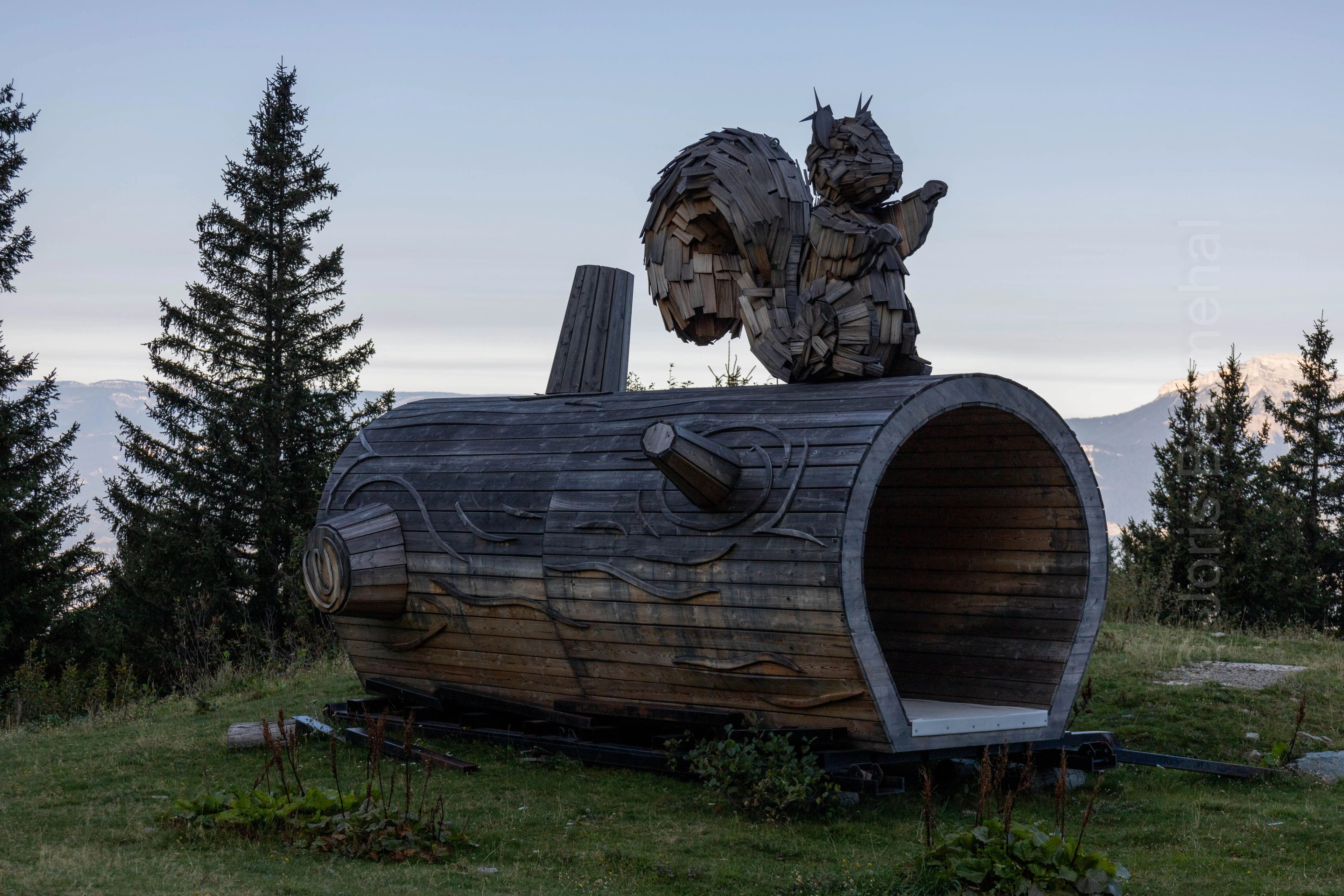 Sculpture en bois d'un écureuil sur un rondin, servant de tunnel pour les pistes de ski à Prapoutel sur le GRP des 7 Laux.