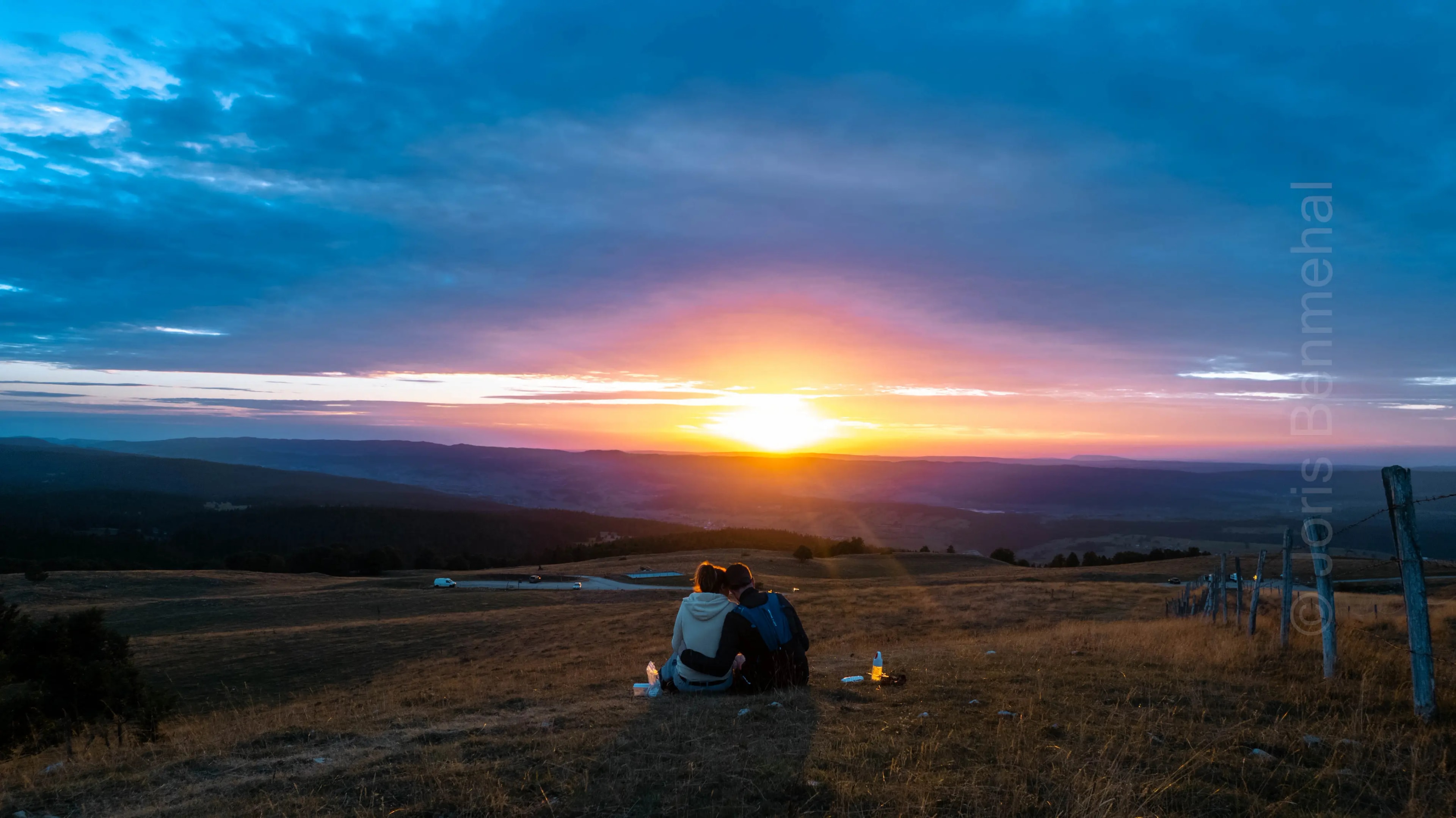Coucher de soleil avec des teintes orange sur les crêtes du Mont d'Or avec en silhouette moi et ma femme.