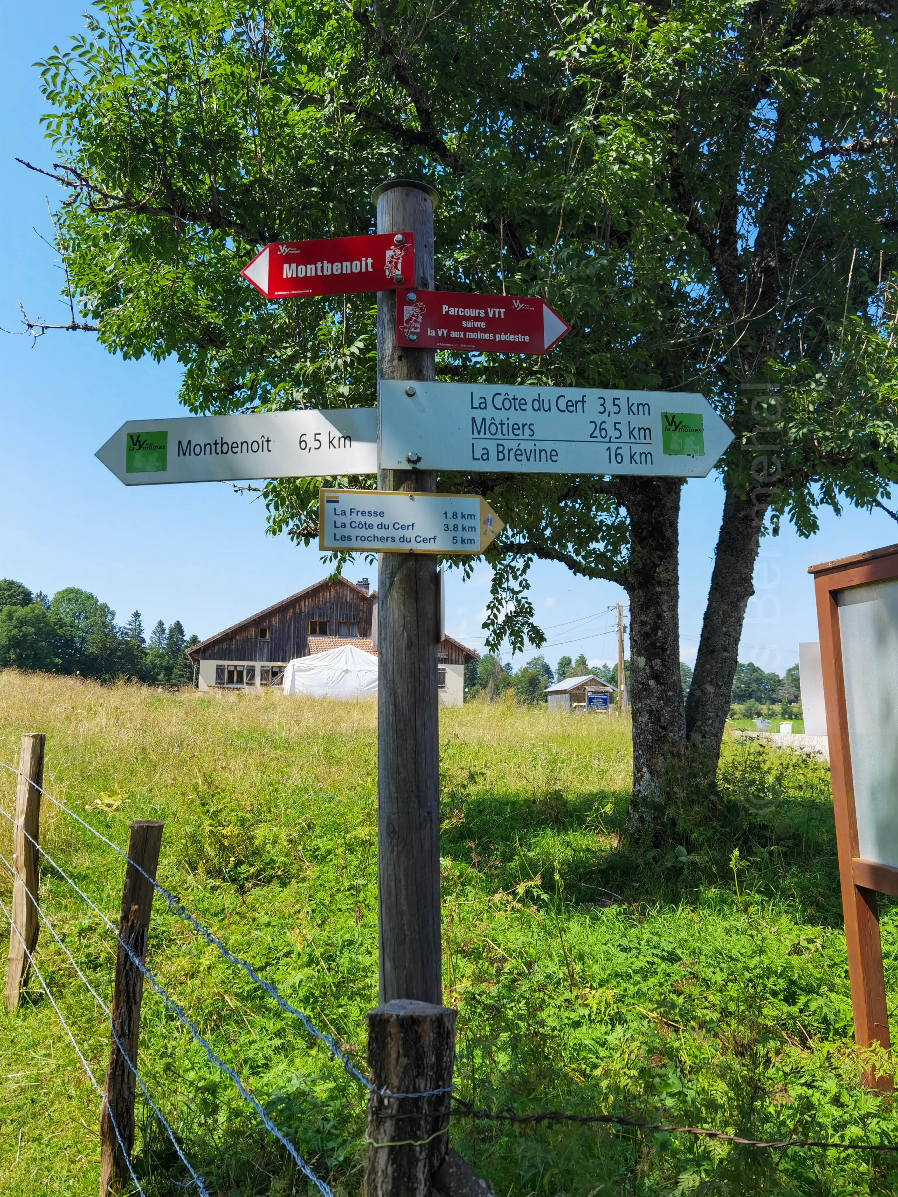 Panneau indicateur de randonnée affichant les distances et directions des différents sentiers.